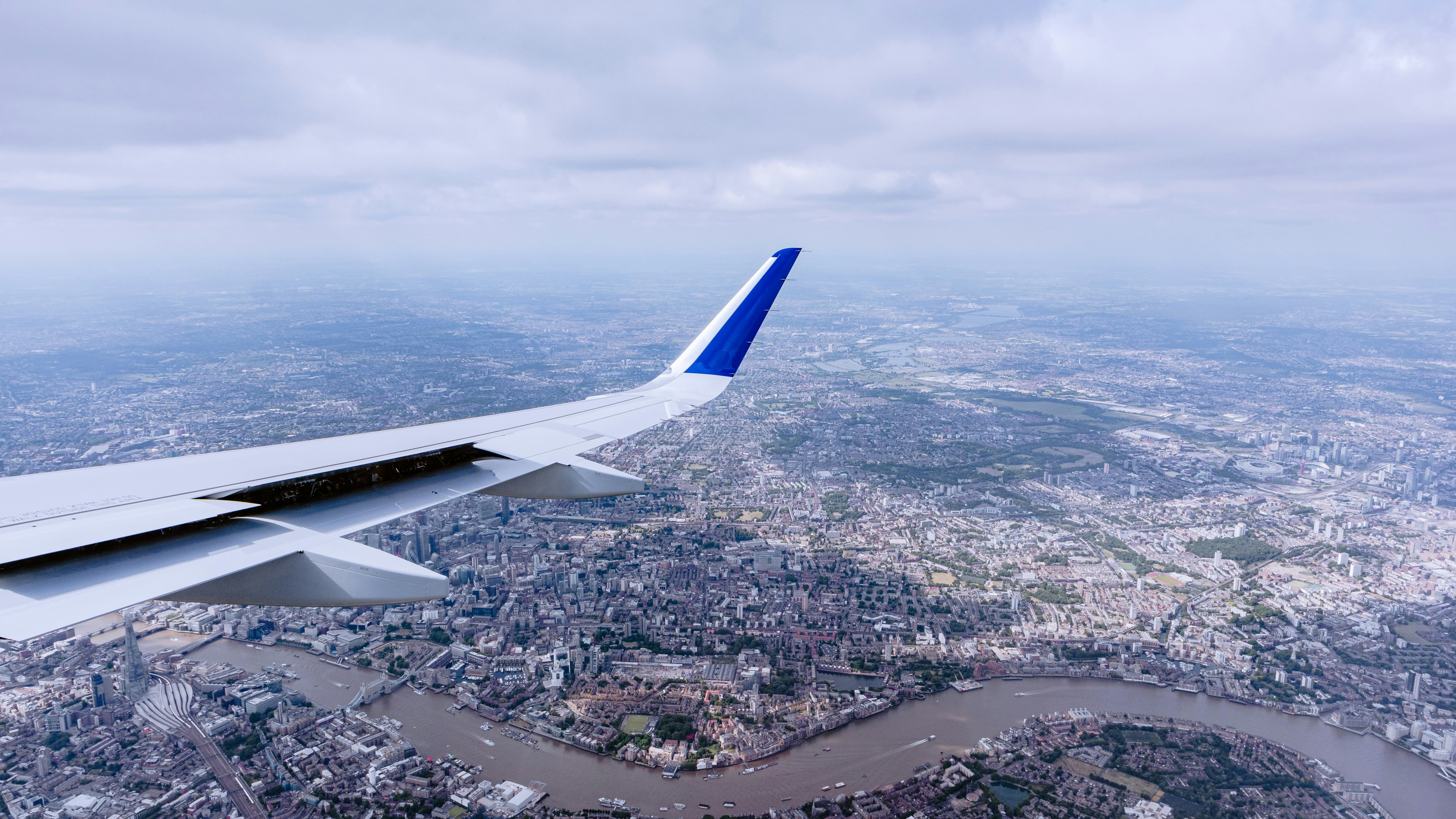 Picture out of airplane window, of wing and city scape